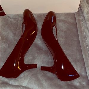 Black patent leather tiny pumps.